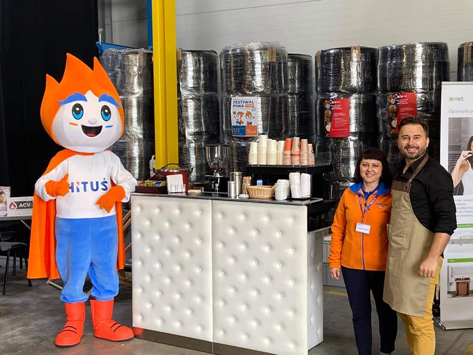 Na fotografii widnieje maskotka w postaci bohatera marki pozująca do zdjęcia na festiwalu piwa